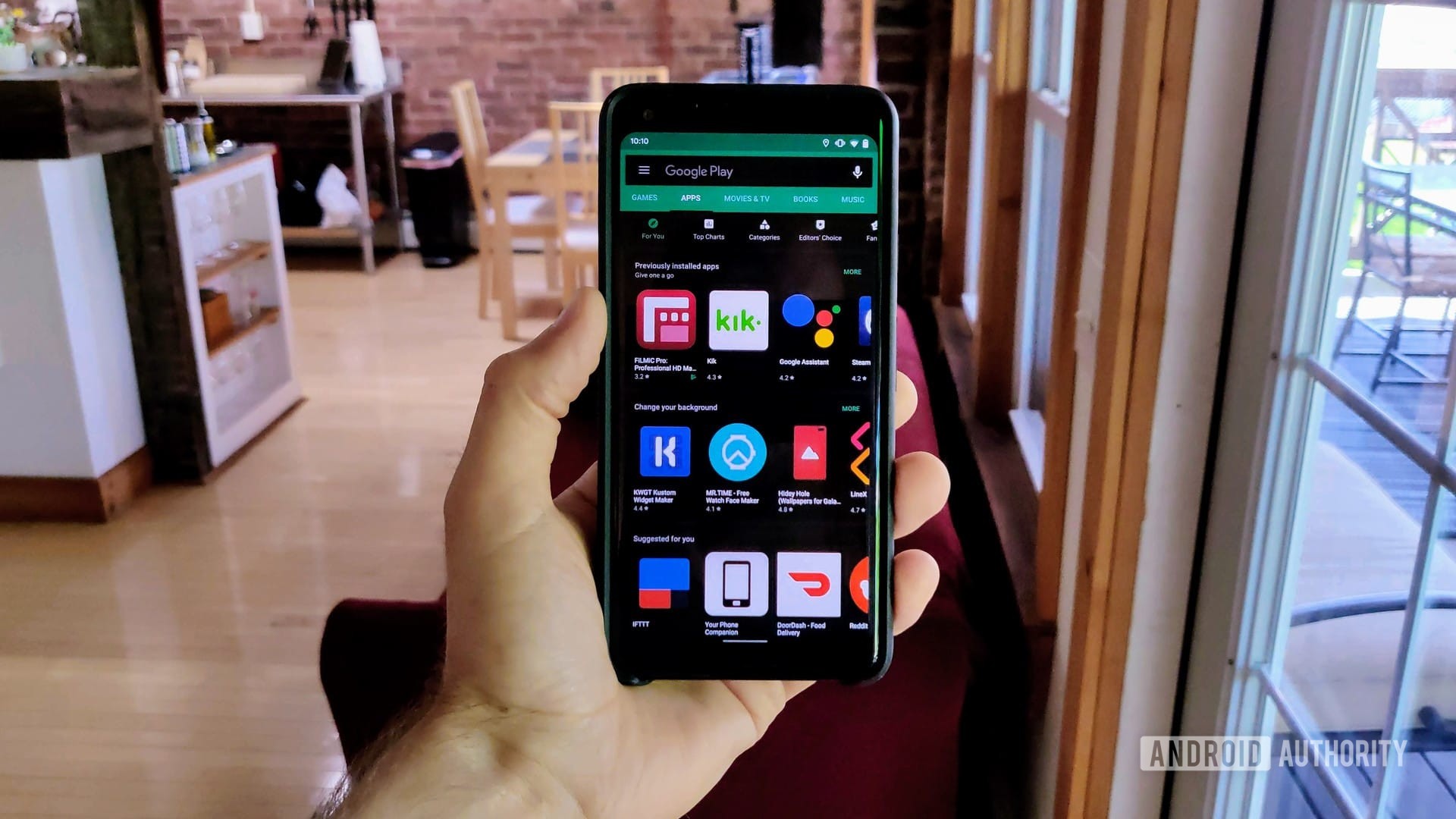 A photograph of a Google Pixel 2 XL with Android Q beta 3, showing how to force dark mode on the Google Play Store.