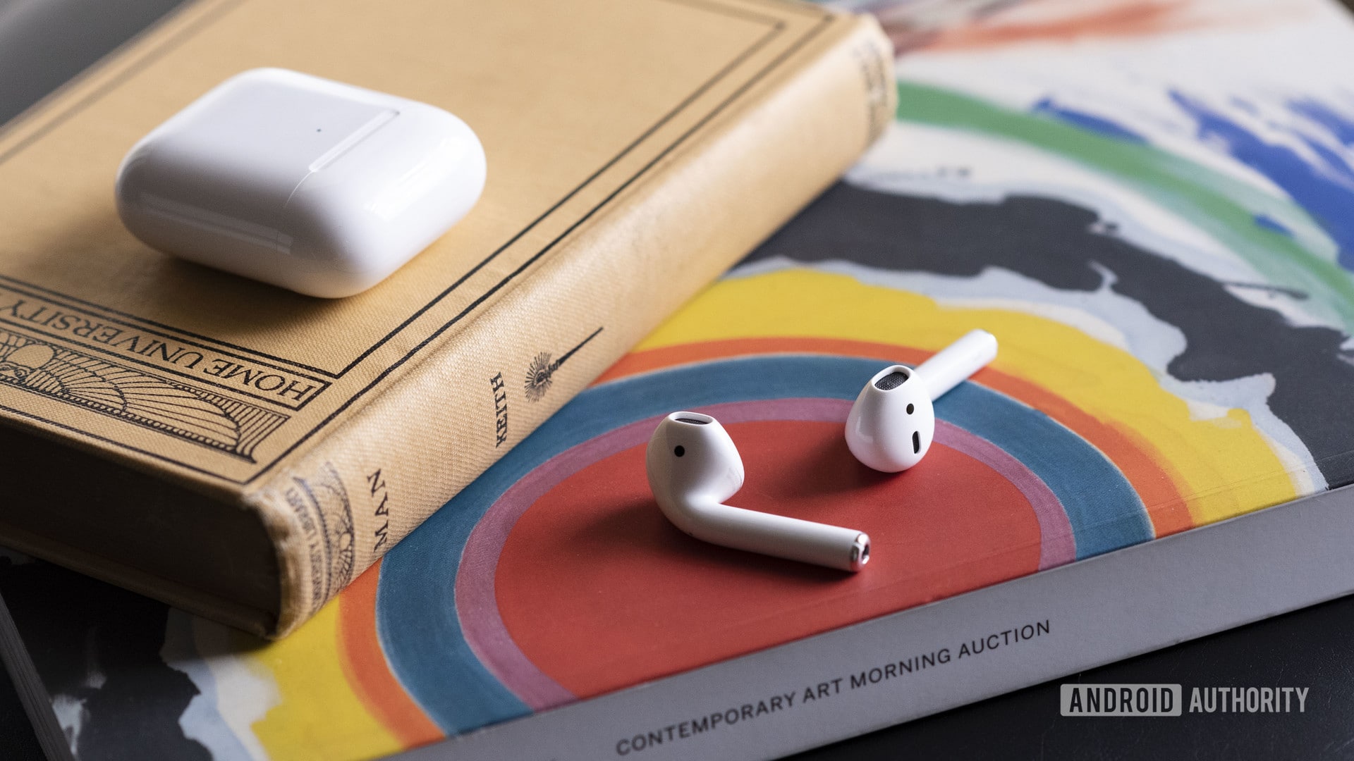 Apple AirPods (2nd generation) outside of the case resting on a book.