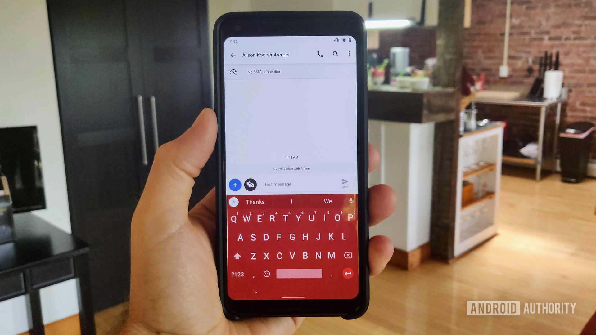 A photo of a hand holding the Google Pixel 2 XL with the latest Google Gboard update which allows for color-matching Android nav bar.