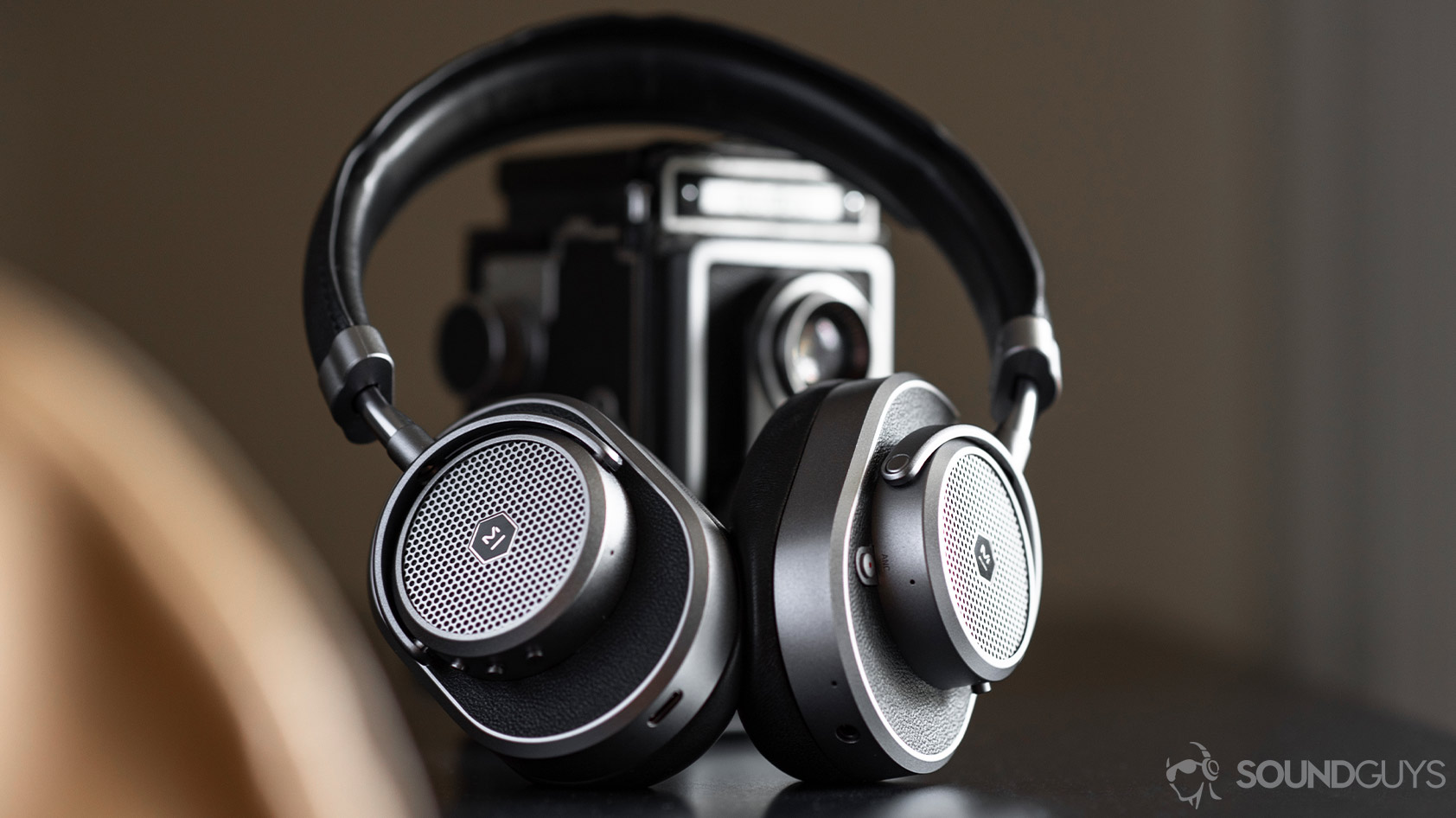 Master &amp; Dynamic MW65: Headphones angled and leaning against a vintage camera.