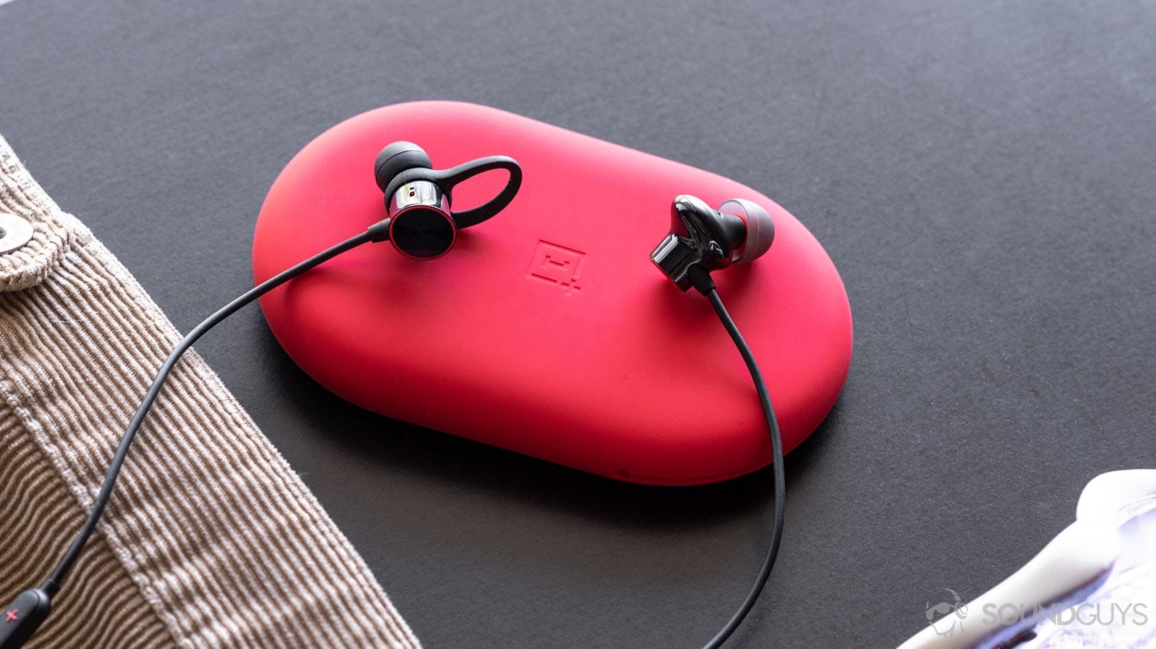 OnePlus Bullets Wireless 2: The old Bullets Wireless on the left and new on the right. They're sitting on the red carrying pouch.