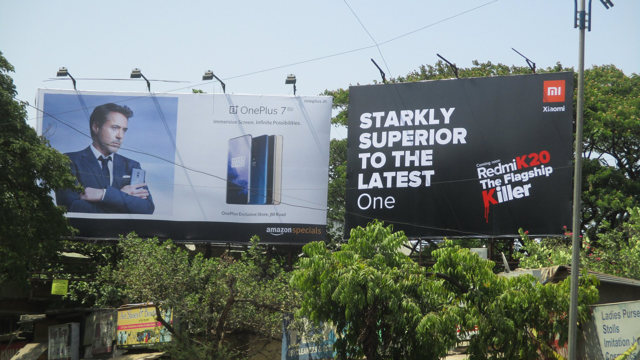 An image of two competing billboards for the smartphone companies Redmi and OnePlus.