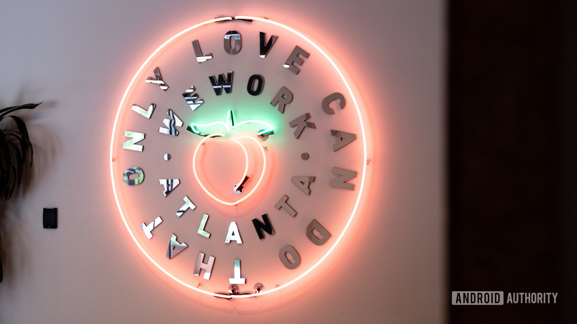 A neon sign welcoming visitors to WeWork in Atlanta. It has a peach in the center.