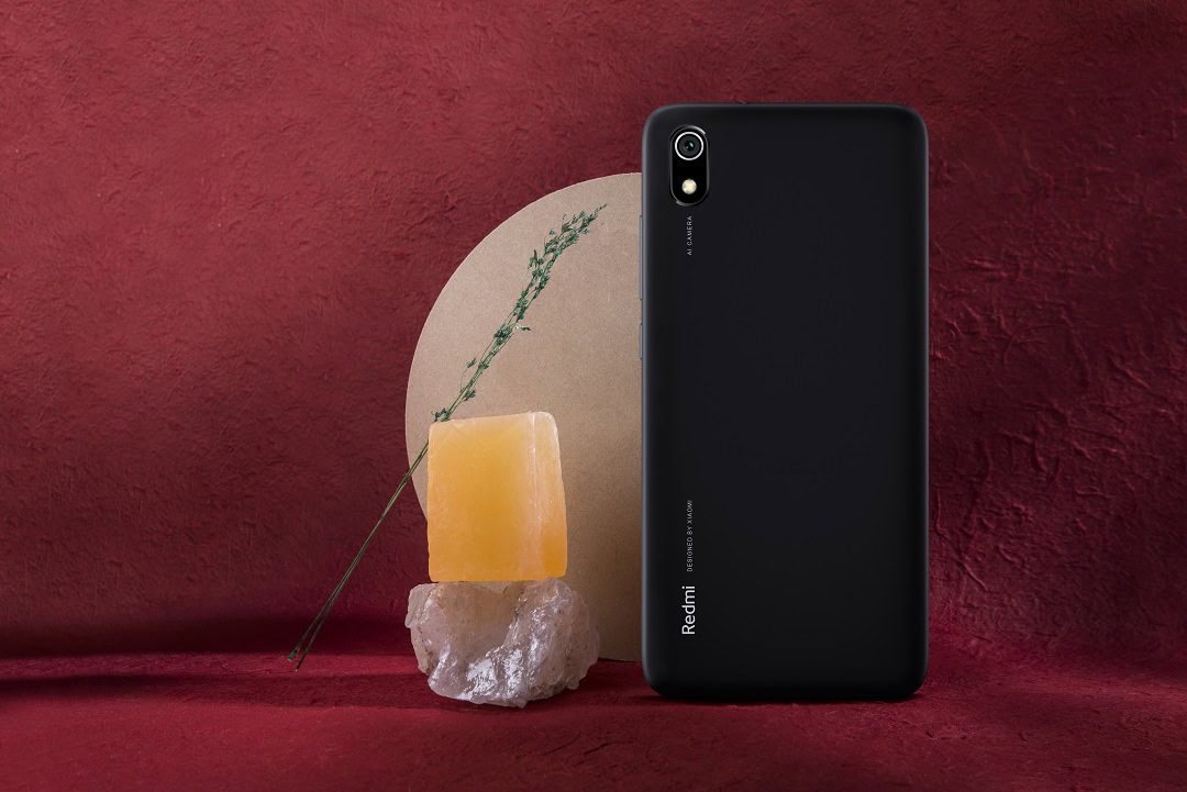 The Redmi 7A in black on a red background.