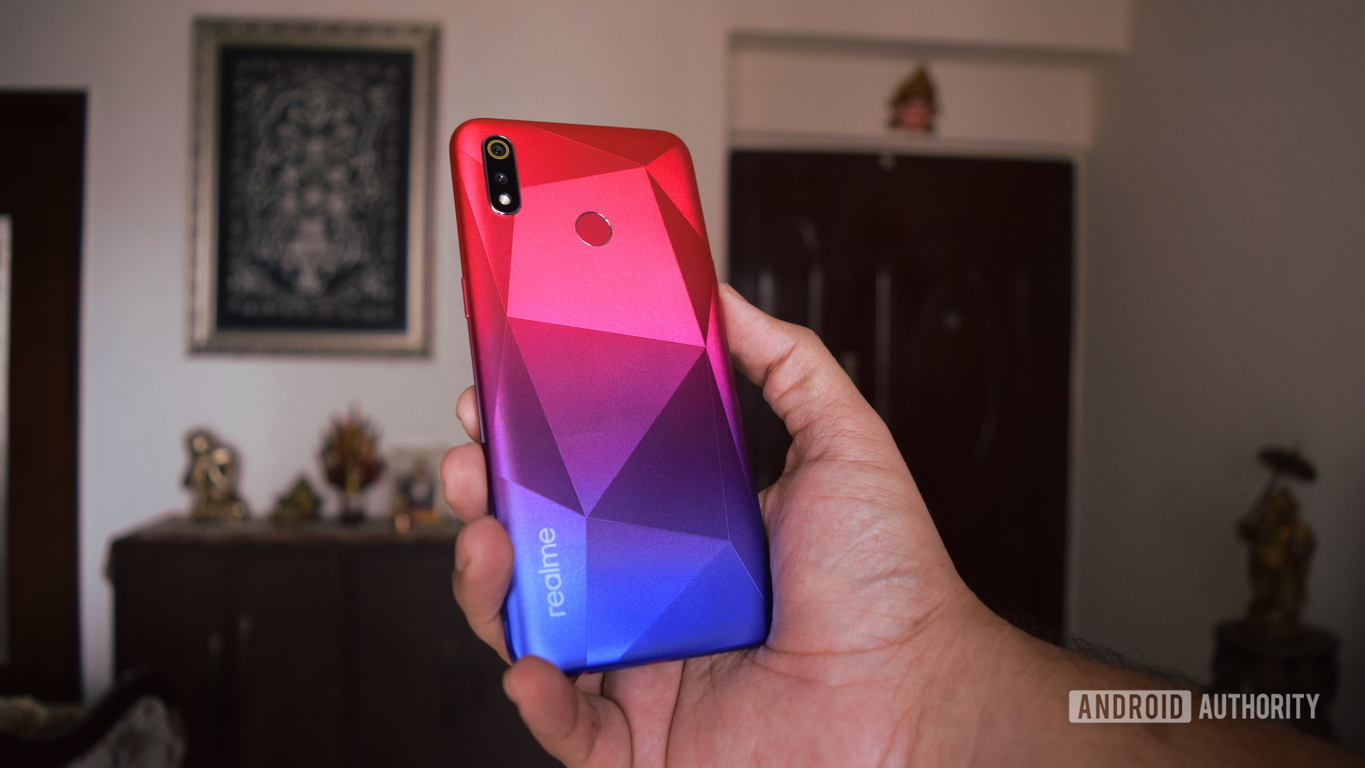 realme 3i in hand showing back