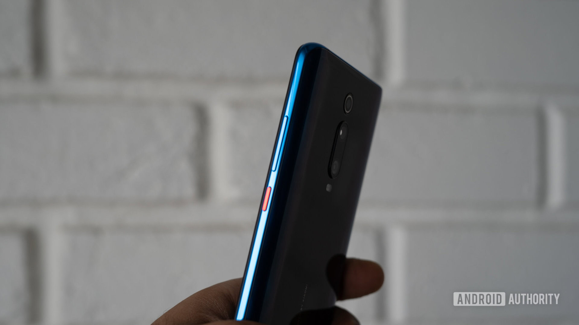 Redmi K20 in hand showing power button and volume rocker