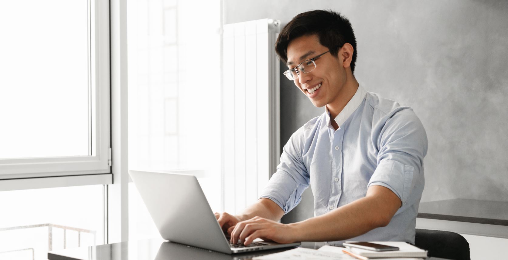 Young Happy Man Typing on Laptop