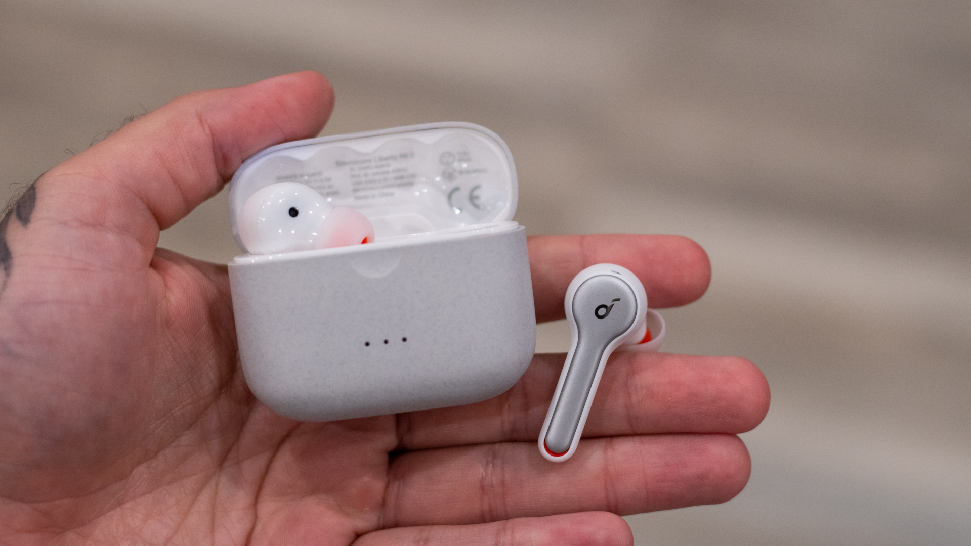 Holding Soundcore Liberty Air 2 earbud and charging case 