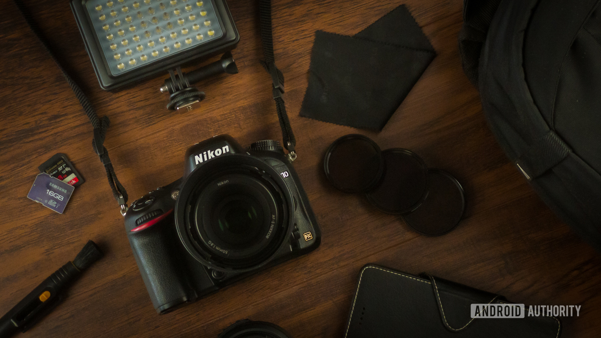 Nikon photography gear including camera, bag, microfiber pen, LED smartphone, SD cards, polarizers, ND filters. 