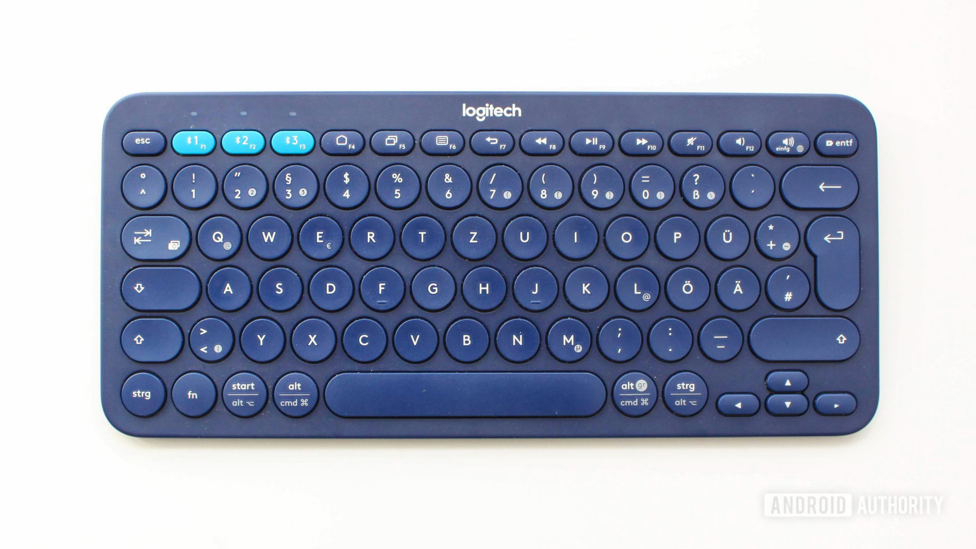 A logitech k380 keyboard in blue on a white table