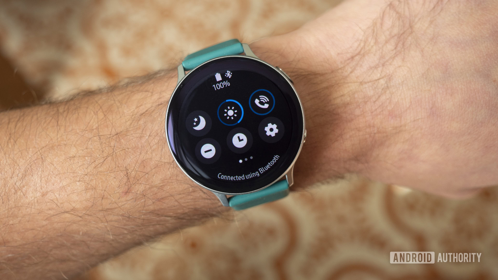 A Samsung Galaxy Watch Active 2 on a user's wrist displays the control panel.