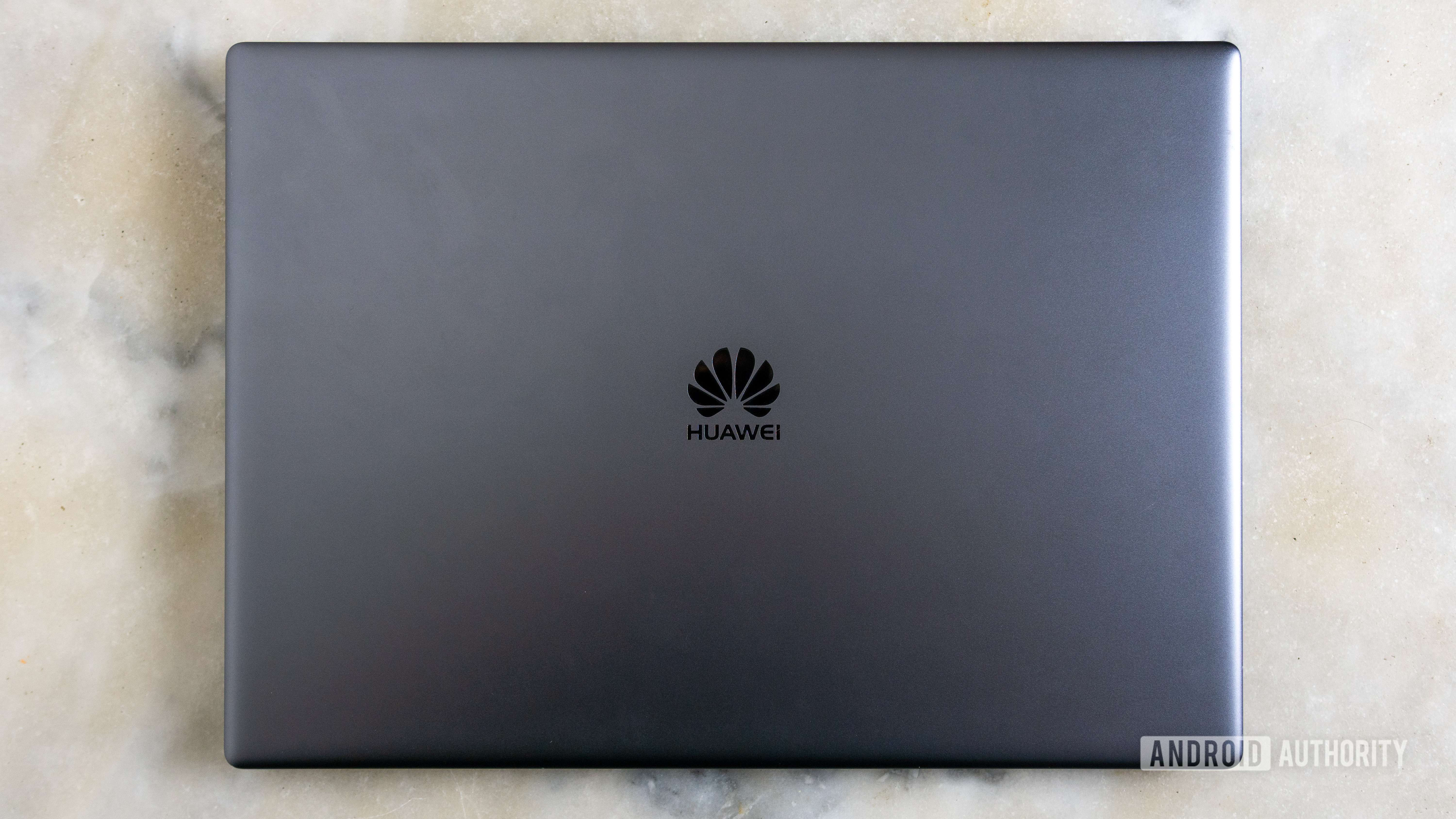 Closed HUAWEI Matebook X Pro laptop on marble table