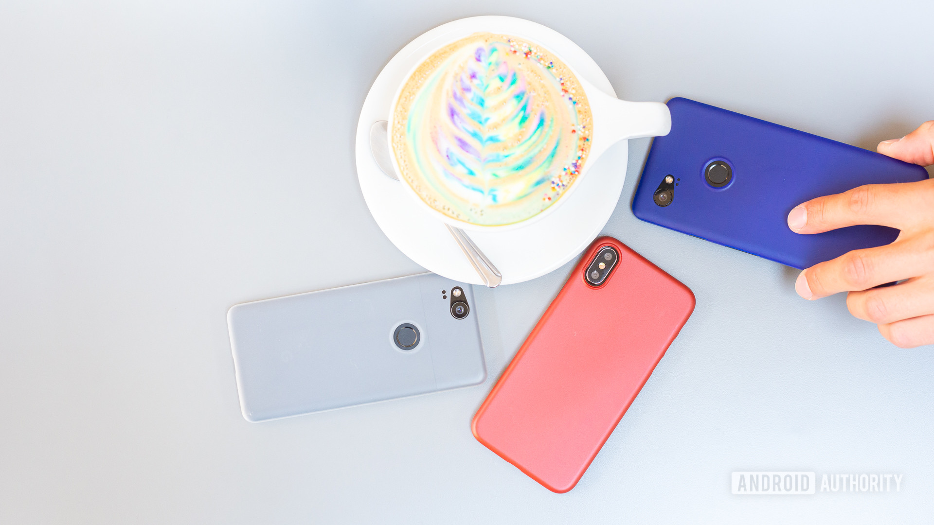 Smartphones on table next to colorful coffee. Selling phones at store. 