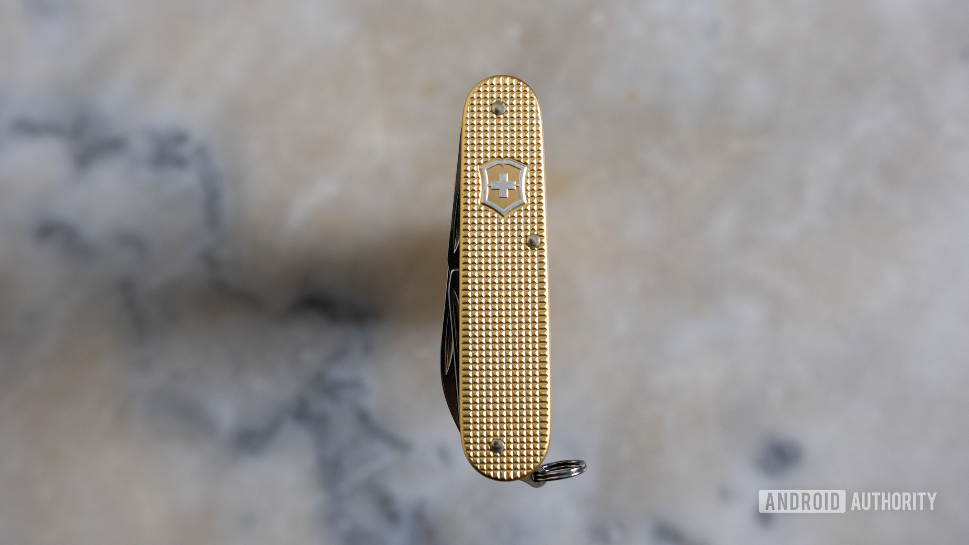 Gold Victorinox Cadet multitool on a marble table