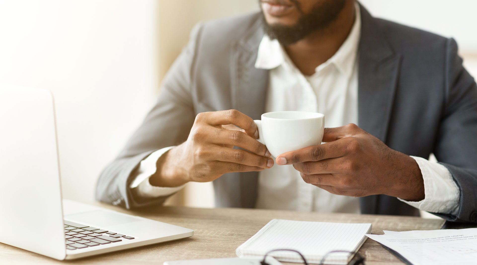 pensive businessman drinking coffee at workplace