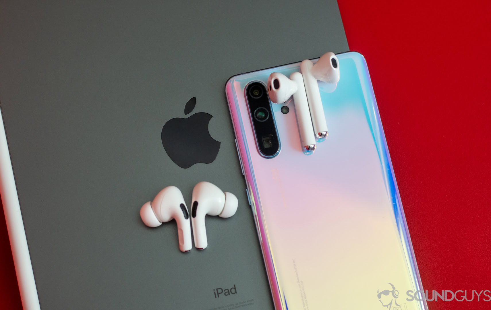 HUAWEI Freebuds 3 on top of P30 Pro phone and AirPods Pro on top of iPad Pro Apple logo