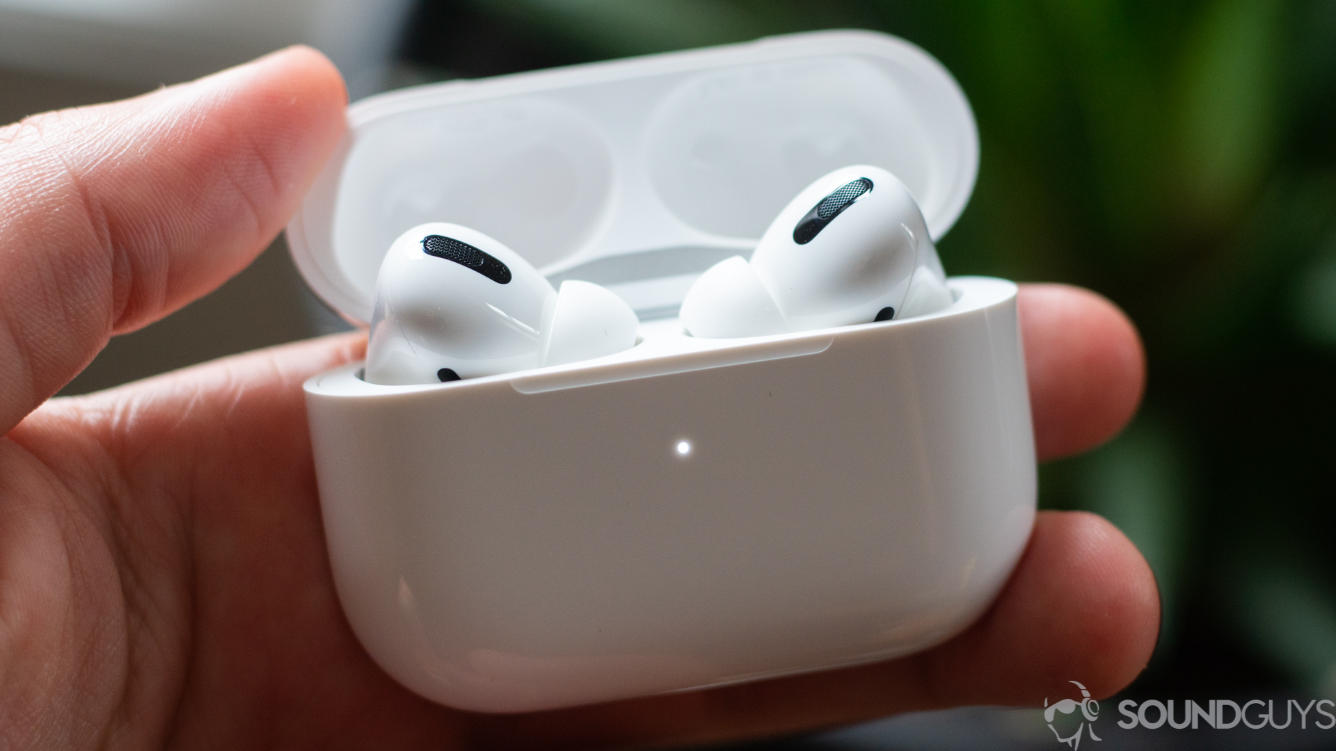 Apple AirPods Pro earbuds charging case in a man's hand.
