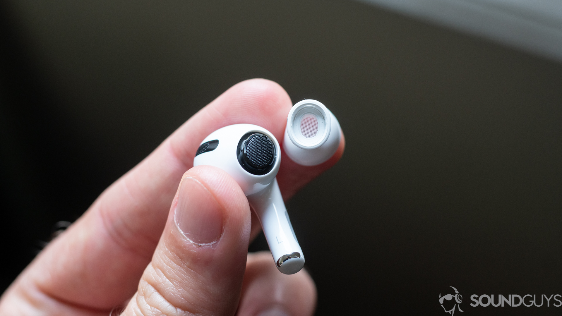 A picture of the Apple AirPods Pro earbud from the earbud and the tip of a man-made silicone ear.