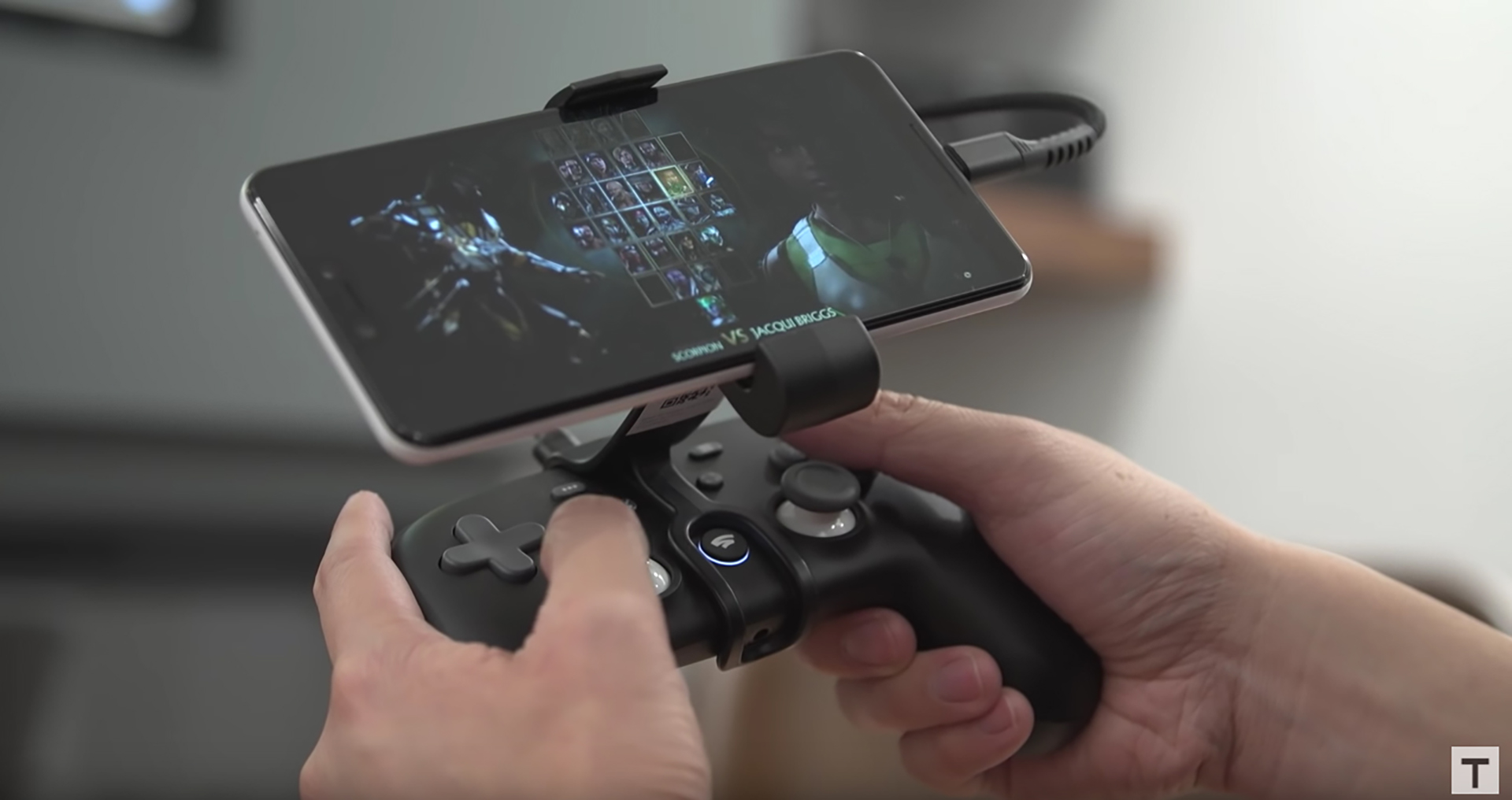 Google Stadia Claw holding a phone, with the controller in hand.