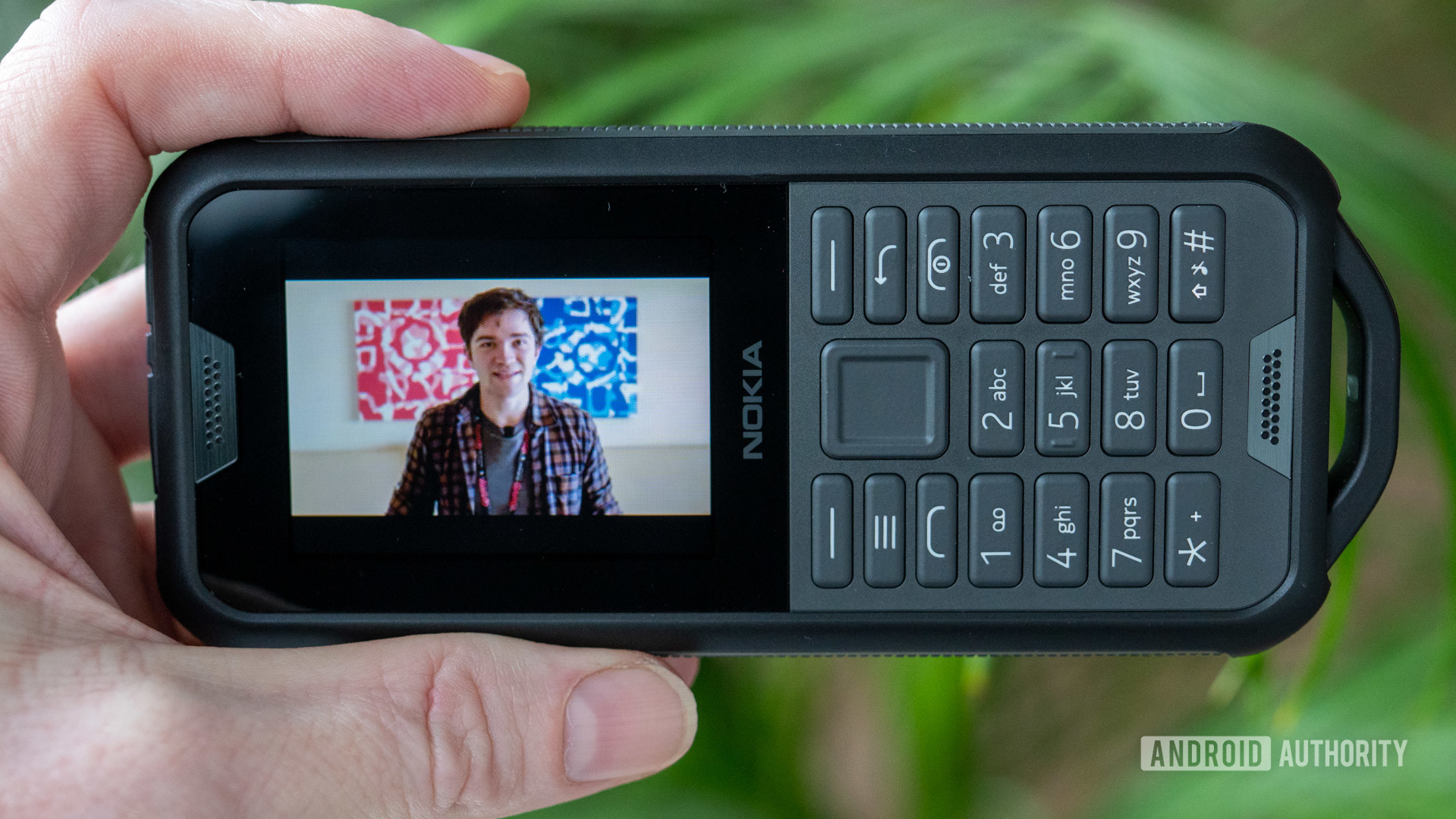 Image of a Nokia 800 Tough being held in sideways, with the screen facing left. The screen shows video of then-Android Authority reporter David Imel.