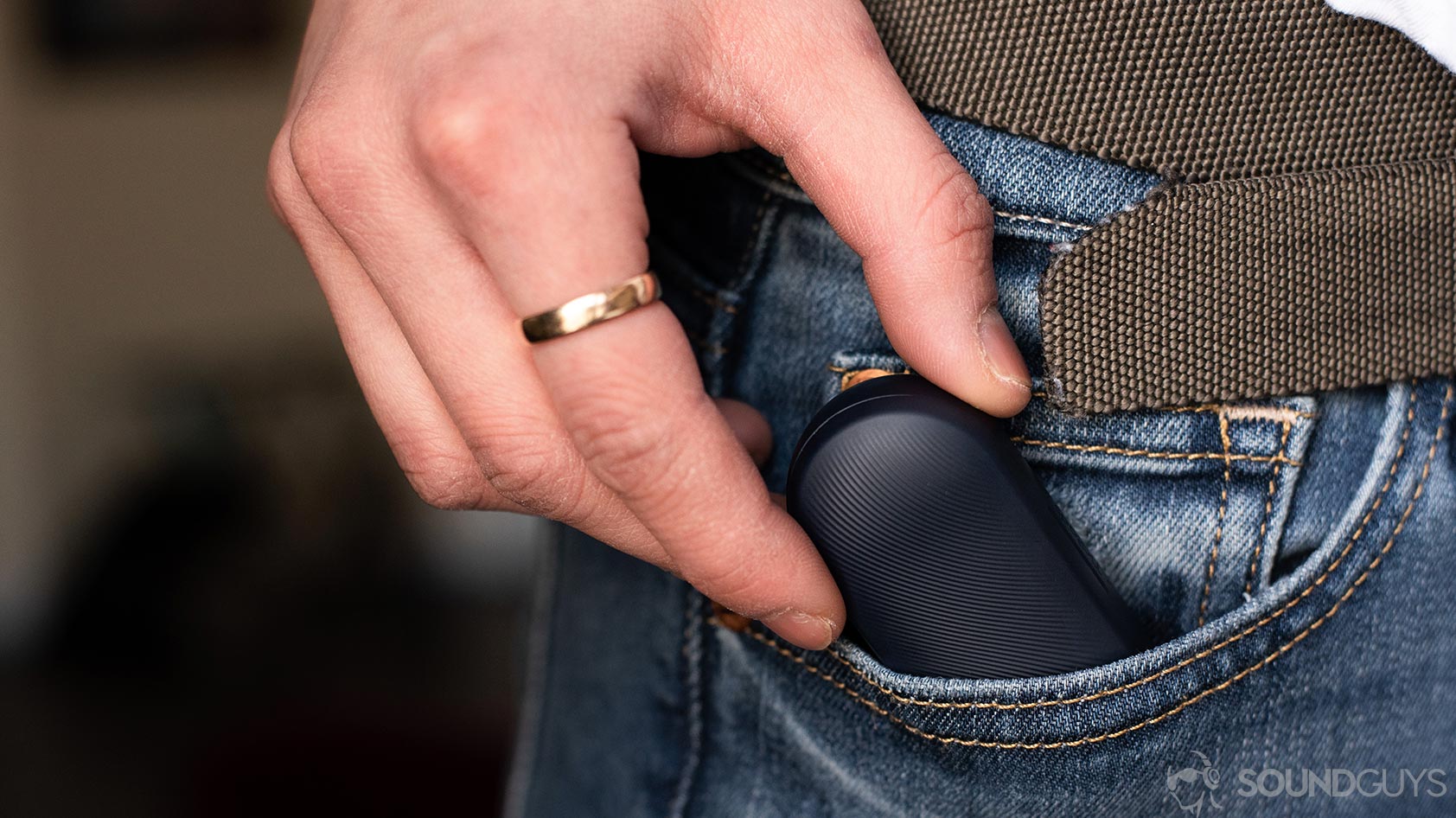 The Mobvoi TicPods 2 Pro true wireless earbuds charging case being removed from a pocket.