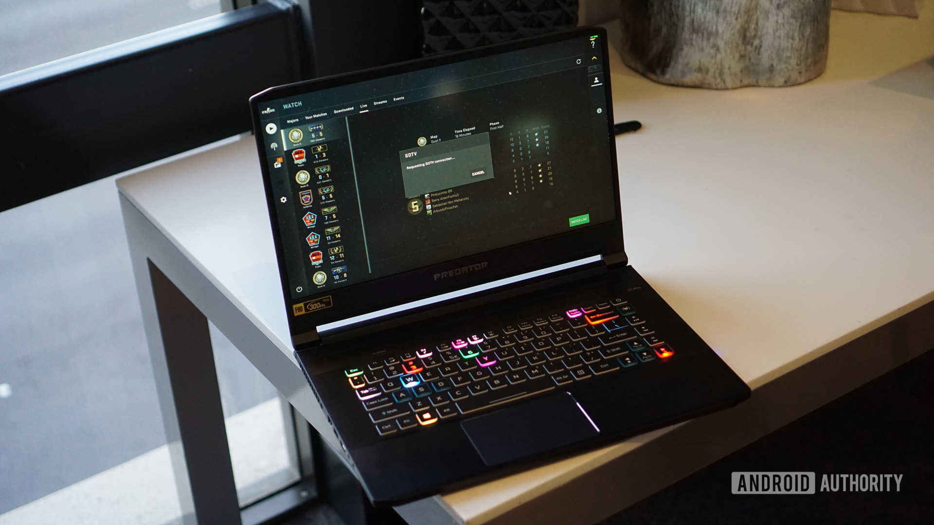 Acer Predator laptop on desk open showing RGB backlit keyboard.