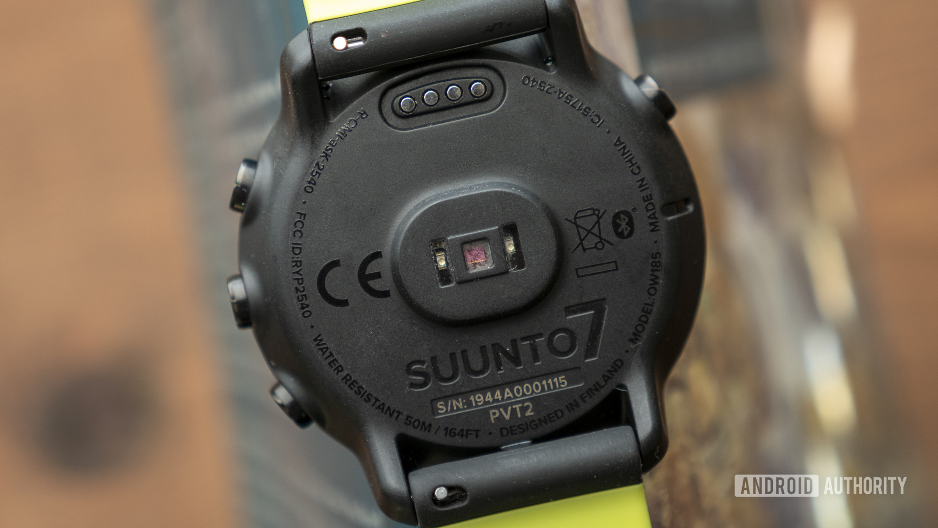 A Suunto 7 rests face down displaying a heart rate sensor.