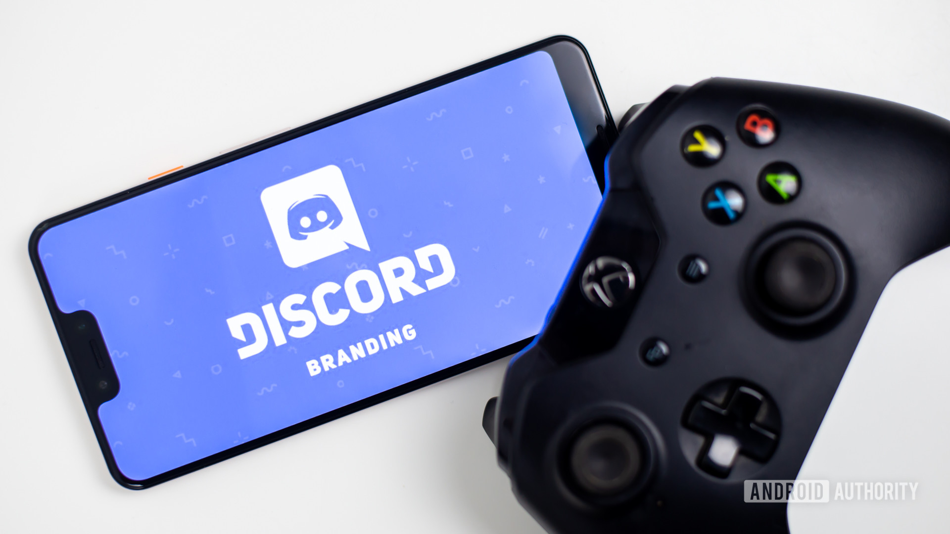 Discord on smartphone next to gamepad stock photo 3