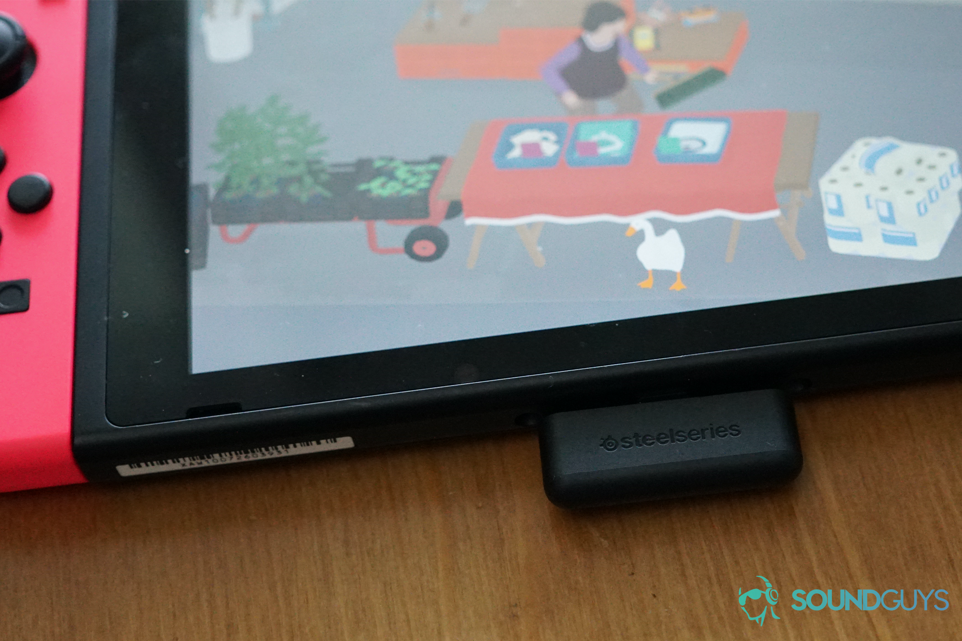 The SteelSeries Arctis 1 Wireless dongle is plugged into a Nintendo Switch running Untitled Goose Game.