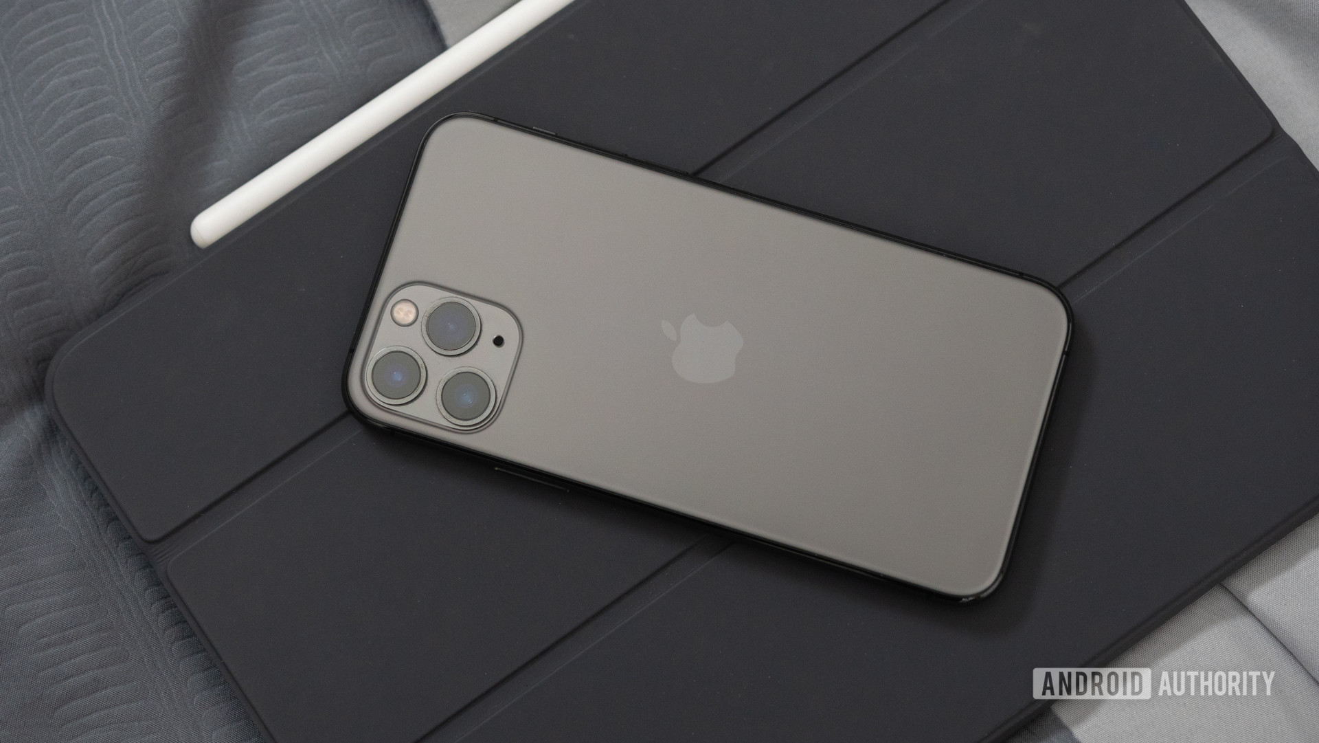 Black iPhone 11 Pro on a gray iPad Pro