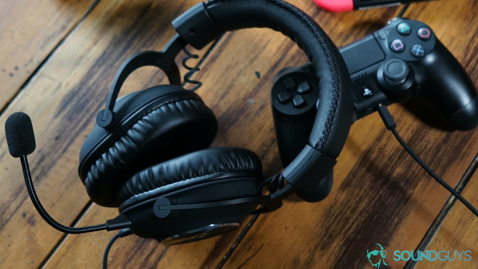 The Logitech G Pro X gaming headset leans on a PlayStation 4 Dualshock controller with a Nintendo Switch behind it.