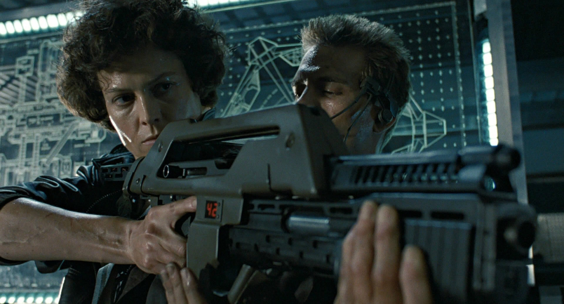 Sigourney Weaver readies her weapon as Ripley in Aliens