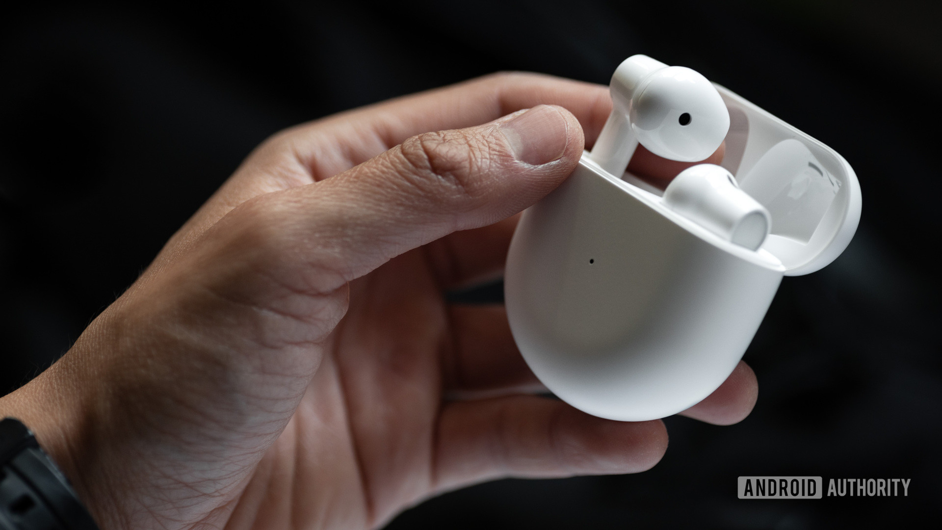 A picture of the OnePlus Buds true wireless earbuds case held in a woman's hand as she removes the left earbud.