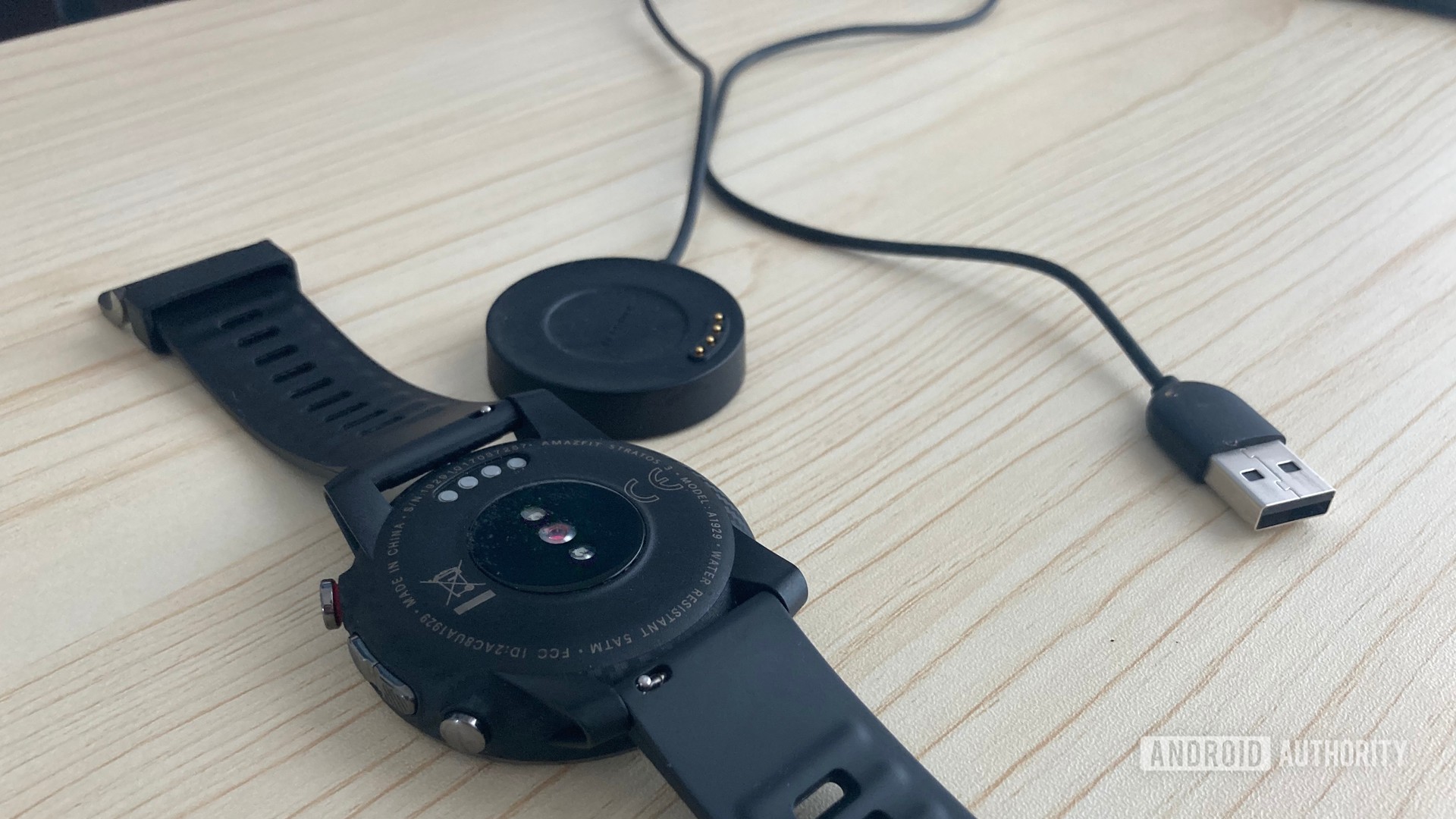 The Amazfit Stratos 3 photographed alongside its charger