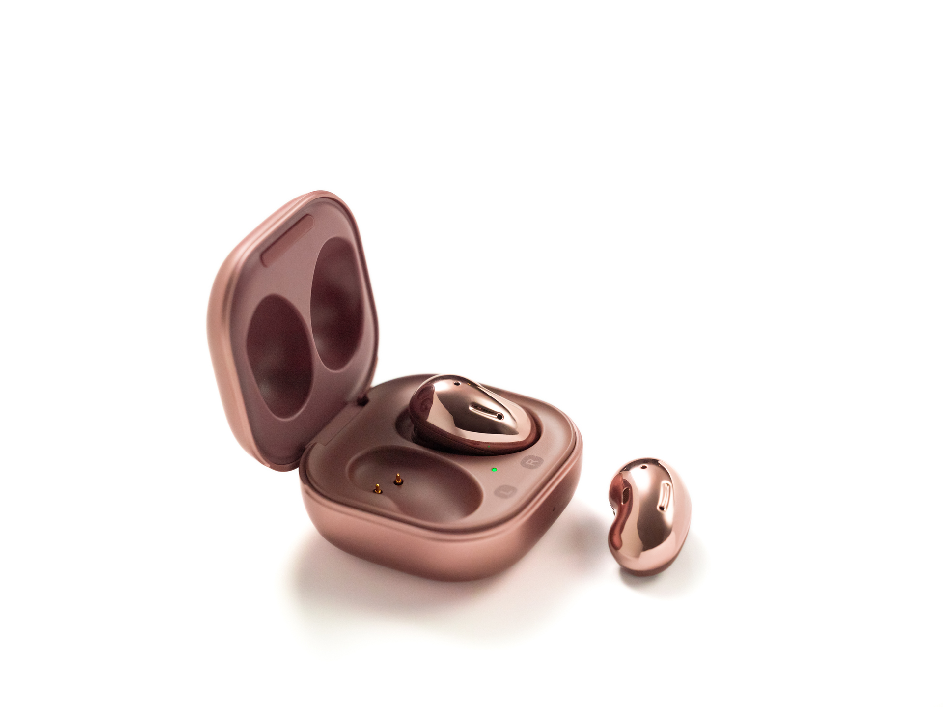 A picture of the Samsung Galaxy Buds Live Mystic Bronze case open with one earbud outside of the case against a white background.
