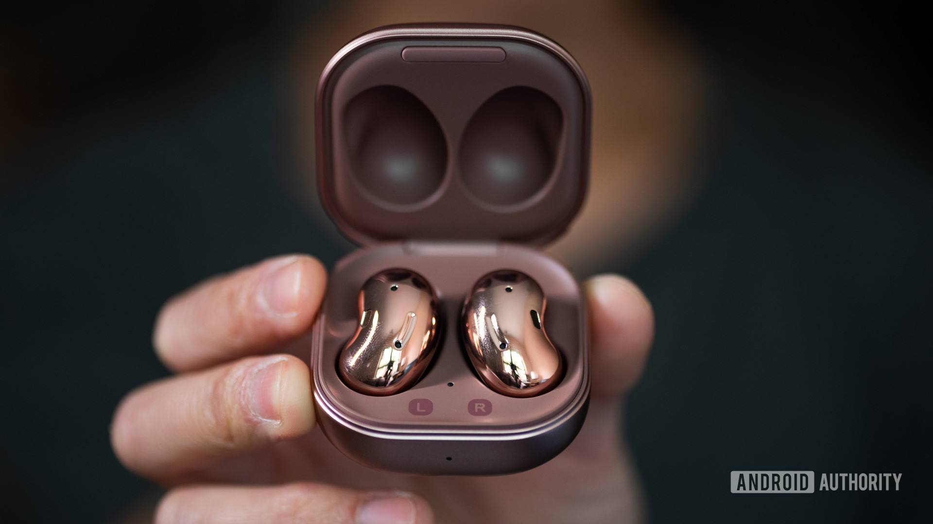 A picture of the Samsung Galaxy Buds Live noise cancelling true wireless earbuds in the case being held in a hand.