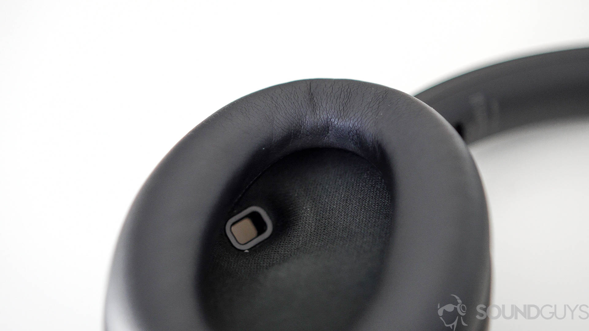 Close-up photo of the proximity sensor on the inside of the left earcup of the Sony WH-1000XM4 headphones.