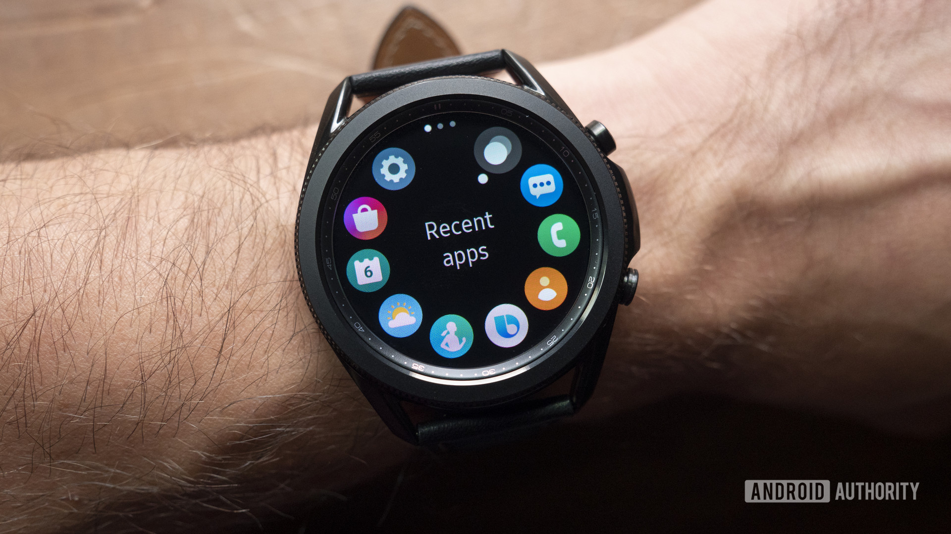 A Samsung Galaxy Watch 3 on a user's wrist displays the device's apps.