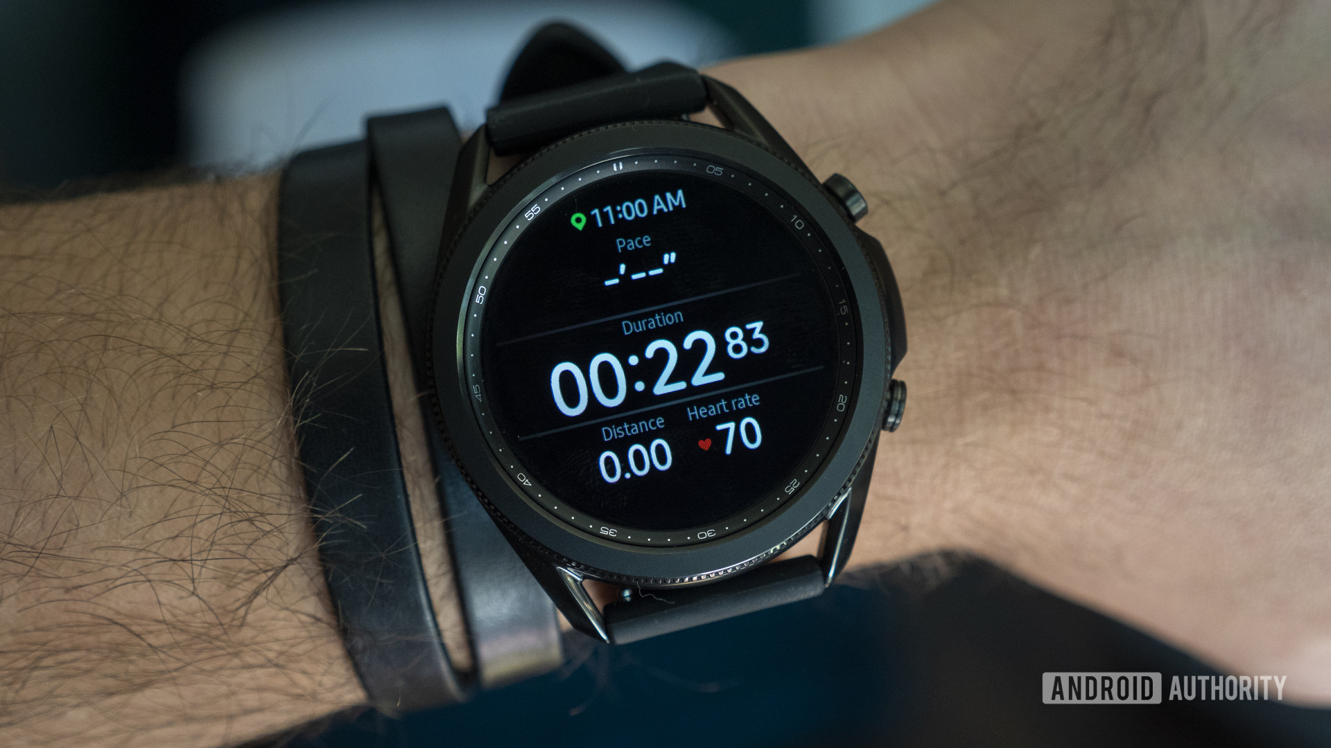 A Samsung Galaxy Watch 3 displays a user's running workout stats including pace, duration, and heart rate.