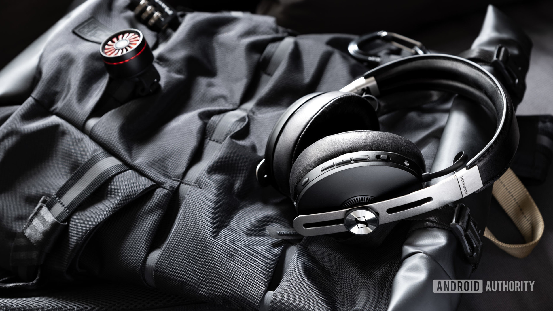 Sennheiser Momentum Wireless 3 Bluetooth headphones in black on top of a passenger backpack.