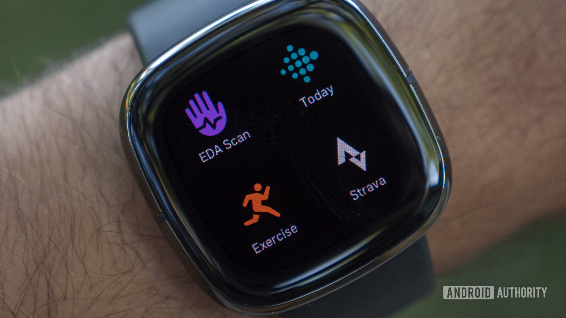 A Fitbit Sense displays a user's apps on screen.