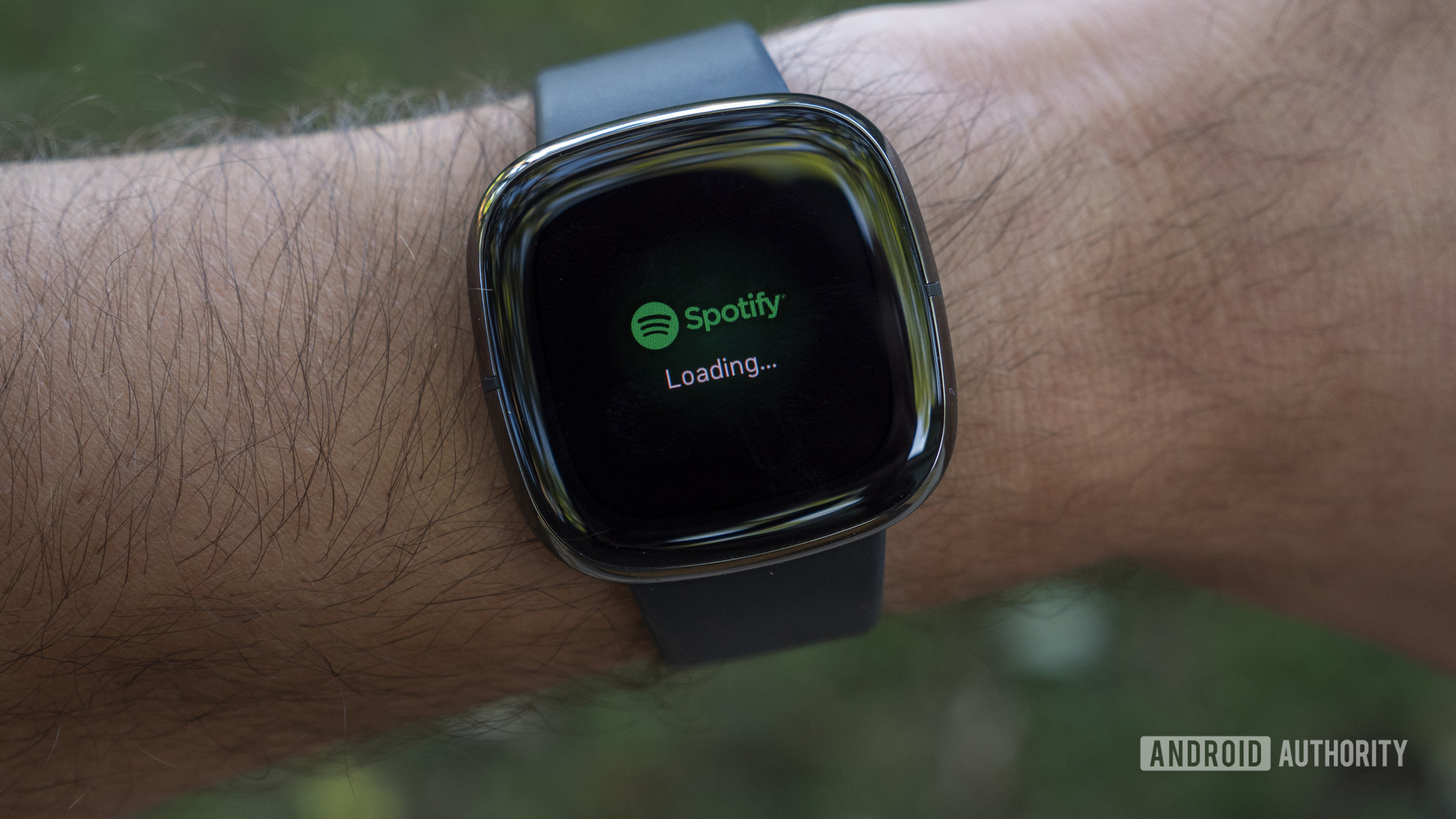 A user loads the Spotify app on their older Fitbit smartwatch.