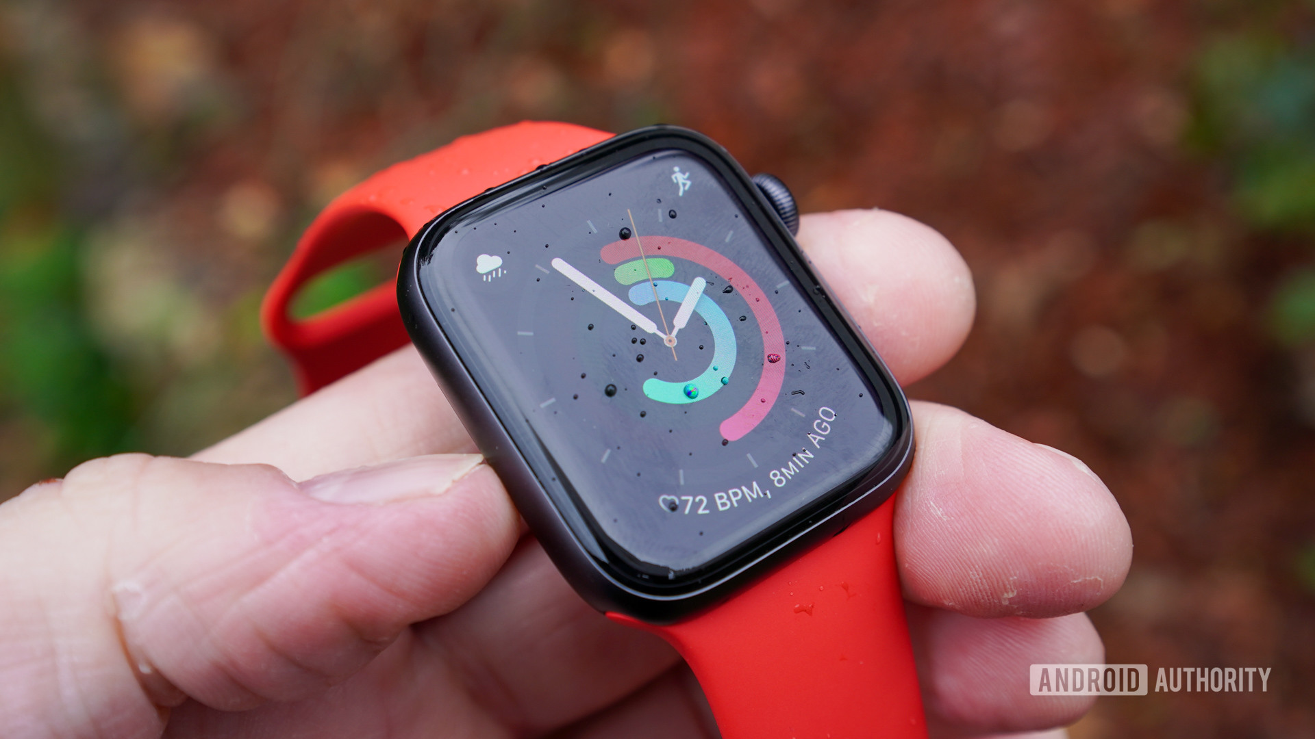 An Apple Watch SE rests in a users hand, displaying a clock face with activity rings.