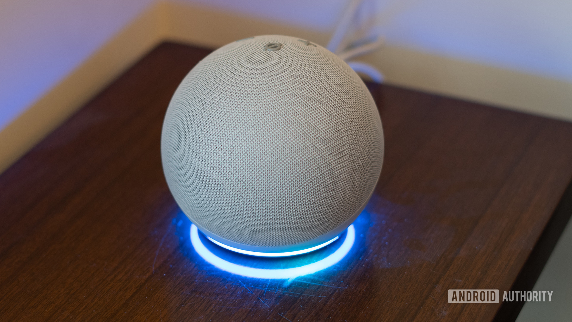 A 4th-gen Echo Dot with a blue ring active