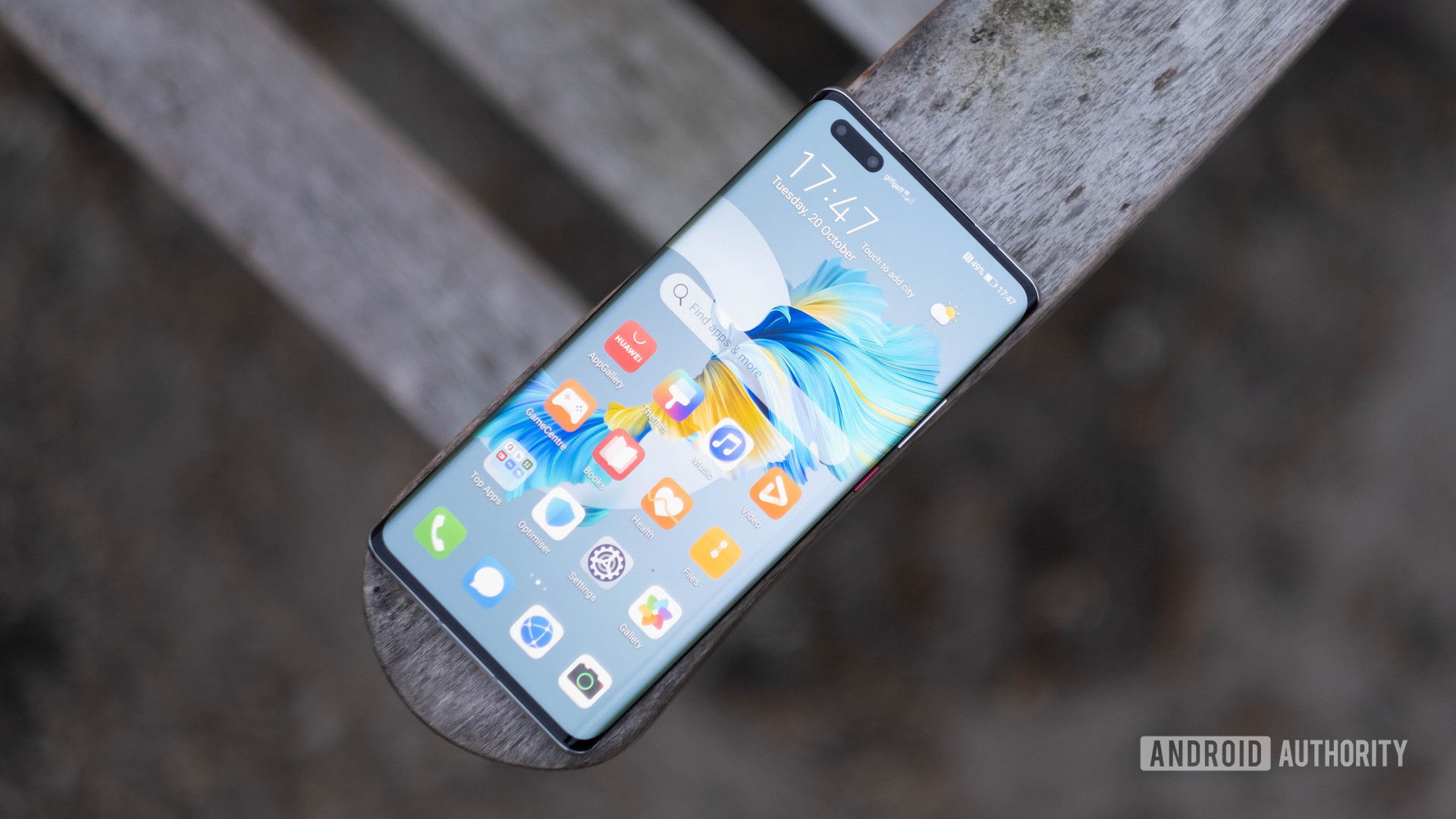 HUAWEI Mate 40 Pro showing the home screen at an angle on a bench