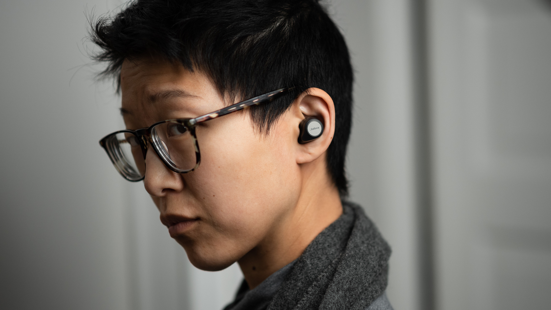 A woman wears the Jabra Elite 85t noise cancelling true wireless earbuds.