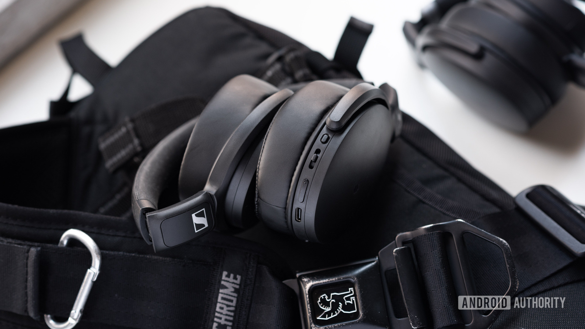 The Sennheiser HD 350BT Bluetooth headphones folded on top of a Chrome sling bag with the Sennheiser HD 450BT in the background.