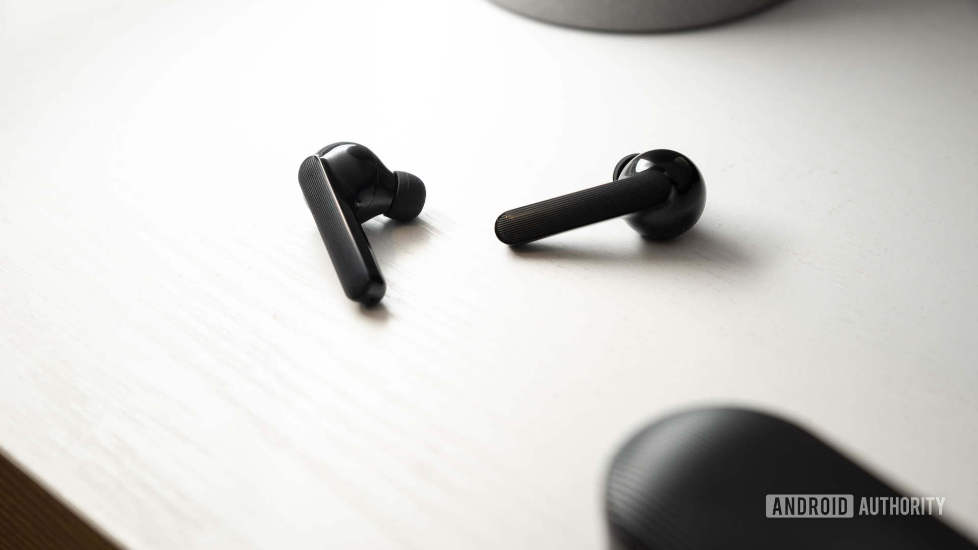 The Mobvoi Earbuds Gesture true wireless earbuds in black against a white surface.