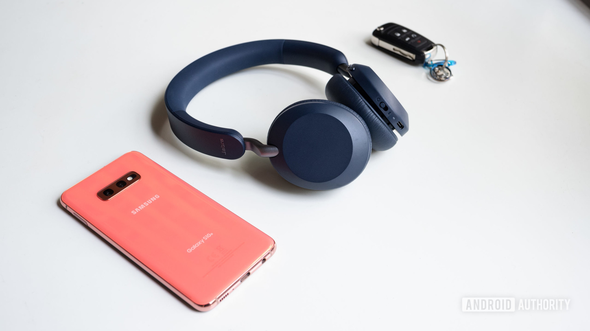 The Jabra Elite 45h on-ear headphones in navy next to a Samsung Galaxy S10e smartphone.