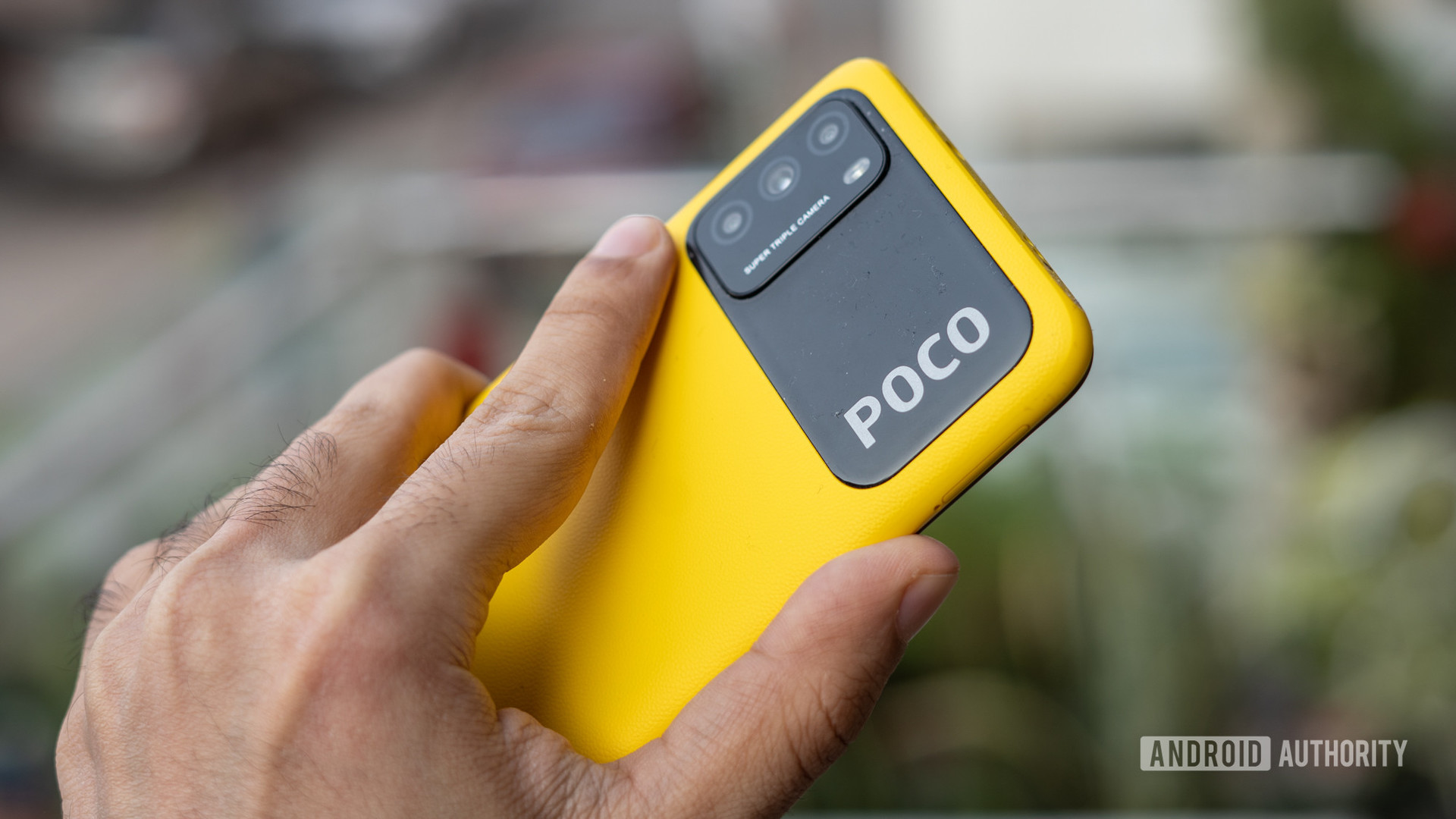 POCO M3 in hand outdoors showing cameraa